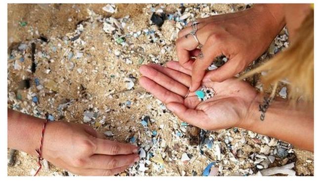 Miembros de la tripulación limpian micro plástico en la playa