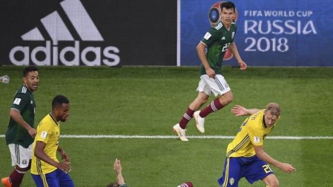 El centrocampista mexicano Héctor Herrera y el delantero sueco Ola Toivonen compiten por el balón durante el partido.