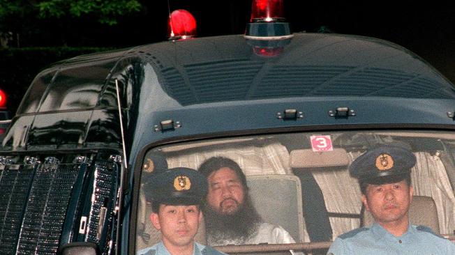 Foto de archivo del 16 de junio de 1995, que muestra al fundador del culto Aum Shinrikyo, Shoko Asahara (c), con nombre de nacimiento Chizuo Matsumoto, quien es escoltado por la policía.