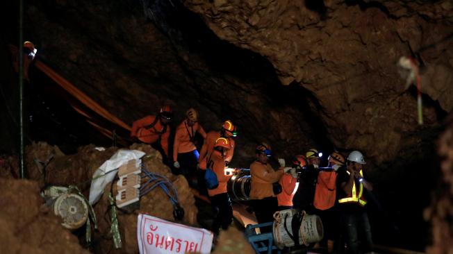 Rescatistas trabajan en las labores para sacar a los niños que faltan y su entrenador de la cueva donde estaban atrapados.