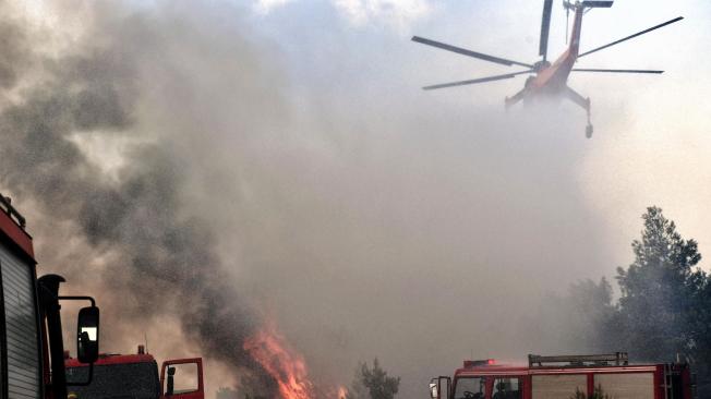 Un helicóptero intentó extinguir los dos grandes incendios este martes, en Verori, cerca de la ciudad de Loutraki (Grecia).