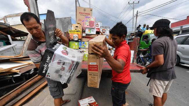Hombres rescatan artículos de las ruinas de una tienda de electrodomésticos en Bangsal, al norte de Lombok, tres días después de que el área fuera afectada por un terremoto.