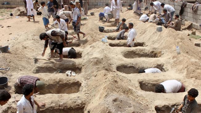 Los yemeníes cavan tumbas para los niños que fueron asesinados cuando su autobús fue bombardeado durante un ataque aéreo.