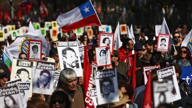 Activistas chilenos de la organización de derechos humanos 'Detenidos desaparecidos' retratan a personas desaparecidas durante la dictadura militar (1973-1990).