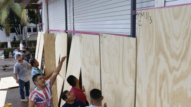 Habitantes protegen sus negocios ante la llegada del huracán Willa, en la ciudad de Puerto Vallarta (México). El huracán Willa alcanzó la mañana de este lunes la categoría 5 en la escala Saffir-Simpson, y se degradó a categoría 4 al acercarse a la costa.
