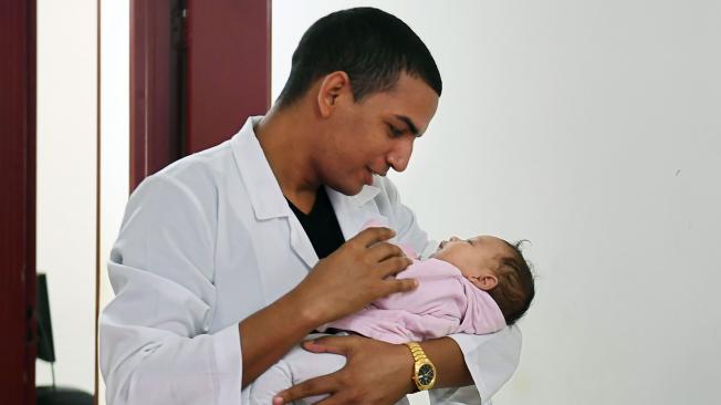 El médico cubano Miguel Pantoja sosteniendo a un bebé en la Unidad de Salud Básica de Alexania, 80 kilómetros al suroeste de Brasilia, capital de Brasil.