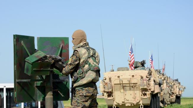 Tropas estadounidenses (d), junto a una milicia de un grupo kurdo en la frontera sirio-turca.