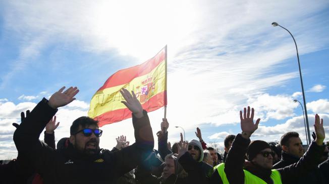 Los taxistas en Madrid sostienen una bandera española que lee "Justicia", en protesta contra las plataformas Uber y Cabify.