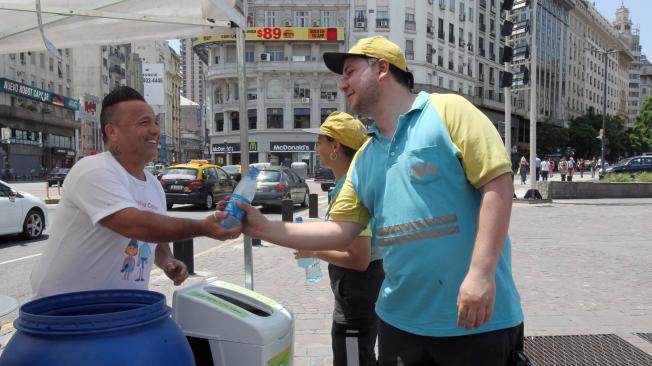 Ciudadanos reciben botellas con agua para refrescarse debido a la ola de calor en Buenos Aires (Argentina). Este miércoles la temperatura subió a 45 grados.