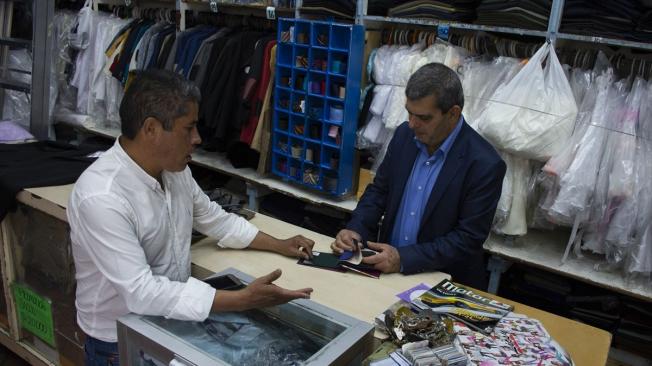 Alí Nofal, migrante palestino radicado en Colombia, atiende 'La nueva galería de la once', uno de los almacenes de ropa que tiene en el centro de Bogotá, en la carrera novena con calle once.