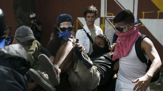 Varios de los manifestantes fueron evacuados tras los choques con las fuerzas militares en Caracas.