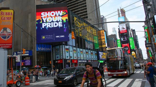 ehículos pasan delante de un edificio cubierto con carteles sobre el Orgullo LGBTI este lunes en Times Square, en Nueva York (Estados Unidos). Con banderas arcoíris ondeando desde hoteles, de edificios de oficinas, casas particulares o incluso las pantallas icónicas de Times Square, Nueva York refuerza su papel como meca global del turismo LGBTI, esperando cuatro millones de visitantes del colectivo solo durante los festejos del WorldPride.