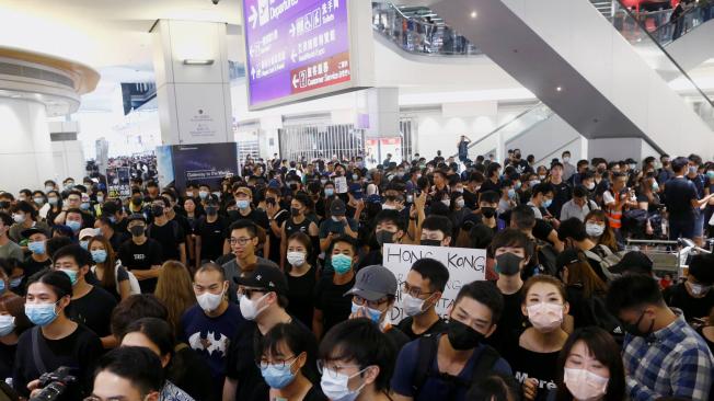 Manifestantes bloquean el acceso a las puertas de embarque, durante una manifestación en el aeropuerto de Hong Kong.