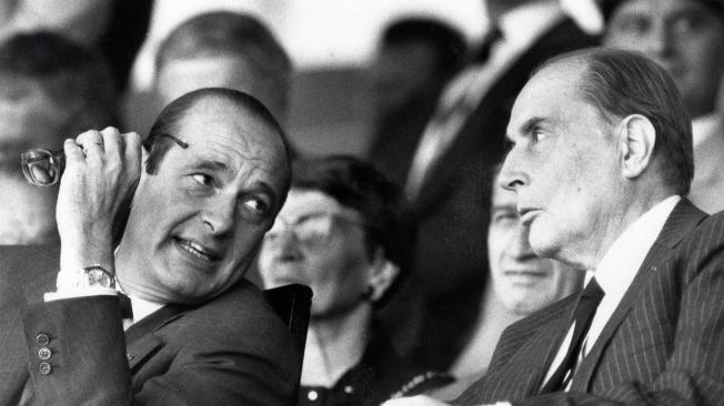 Jacques Chirac (i), primer ministro francés y alcalde de París, habla con el presidente socialista francés Francois Mitterrand durante el desfile militar anual del Día de la Bastilla en esta imagen sin fecha.