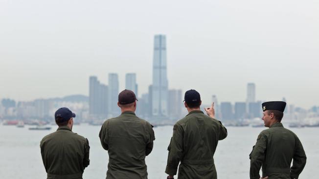Foto de archivo tomada en agosto de 2014 que muestra a personas de la Marina de EE. UU. en el USS Makin Island, mirando el Centro Internacional de Comercio, en Hong Kong.