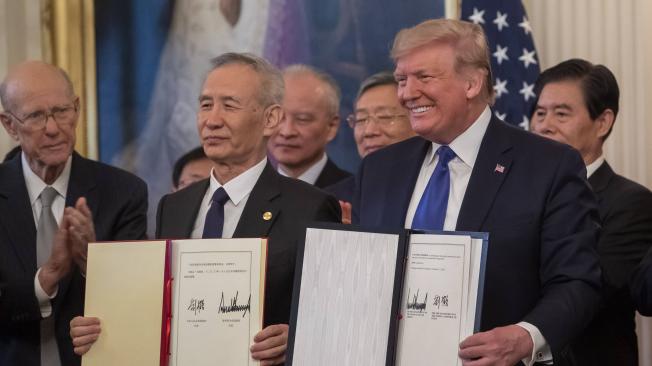 El presidente de EE. UU., Donald Trump (der.), y el viceprimer ministro de China Liu He (izq.), con el acuerdo firmado este miércoles.