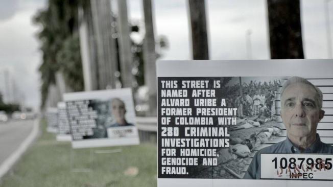 Estas pancartas, que dan cuenta de las investigaciones en contra del expresidente, fueron puestas a un costado de la llamada calle Álvaro Uribe Way.