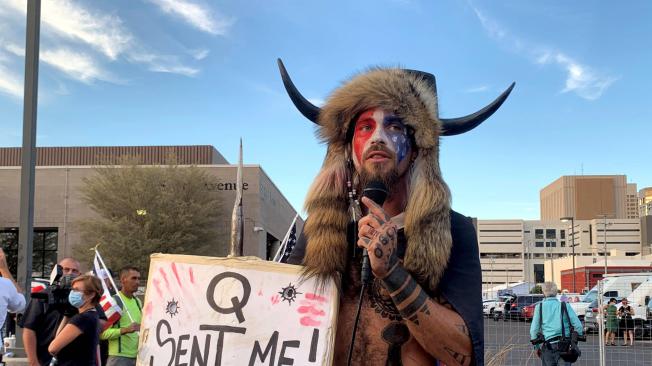 'Q' es uno de los usuarios que empezó a compartir las bases de esta teoría. En el letrero que sostiene el manifestante dice 'Q me envió'.