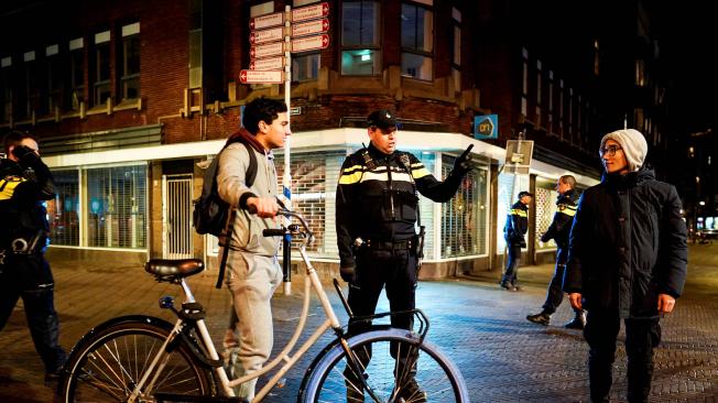La policía habla con habitantes en una calle de Grote Marktstraat en La Haya.
