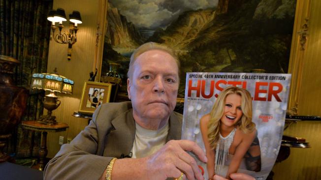 En esta foto de archivo tomada el 26 de agosto de 2014, el magnate del porno Larry Flynt posa con un número de la revista Hustler mientras habla sobre el 40 aniversario de la revista en sus oficinas de Beverly Hills, California.