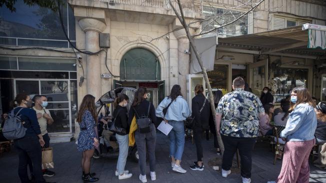 Clientes esperan en una fila para ingresar a un restaurante en Jerusalén.
