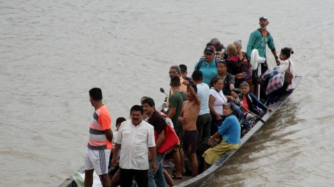 Migrantes venezolanos cruzan en botes desde La Victoria, en Venezuela, hasta Arauquita, en Colombia.