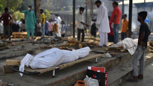 Los cuerpos de muertos por covid-19 yacen en el suelo, mientras son llevados a cremación.