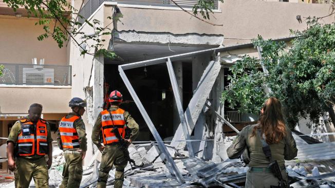 Un equipo de rescate israelí inspecciona una casa alcanzada por un cohete disparado desde la Franja de Gaza en la ciudad de Ashkelon, en el sur de Israel, el 20 de mayo de 2021.