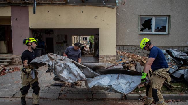 Los bomberos transportan escombros de una casa dañada después de un tornado en Moravska Nova Ves, República Checa, el 25 de junio de 2021.