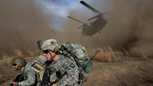 11 de noviembre de 2009, soldados del Ejército de los EE. UU. De la 101.a División Aerotransportada de Infantería 2-506 y del Ejército Nacional Afgano se apresuran para apartarse del camino de un helicóptero Chinook CH-47 que aterriza en territorio hostil durante el lanzamiento de la Operación Radu Bark VI en las montañas Spira en la provincia de Khost, a cinco kilómetros de la frontera entre Afganistán y Pakistán.
