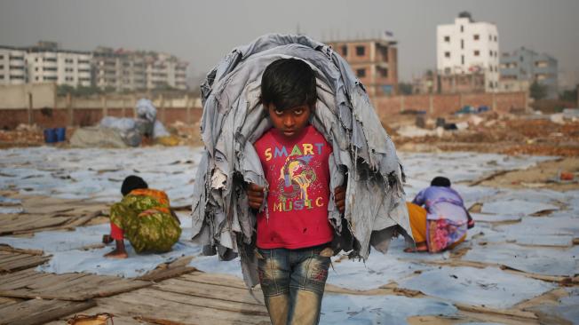 Niño de 10 años trabaja para ganar un dólar al día en una zona de bajos ingresos en Dhaka (Bangladés).