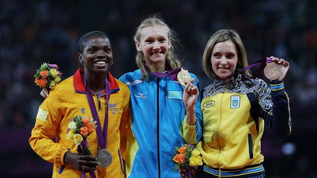 De izquierda a derecha, Caterine Ibargüen de Colombia (plata), Olga Rypakova de Kazajistán (oro), y Olha Saladuha de Ucrania (bronce), celebran tras el salto triple femenino obtenido en los Juegos Olímpicos de Londres 2012.