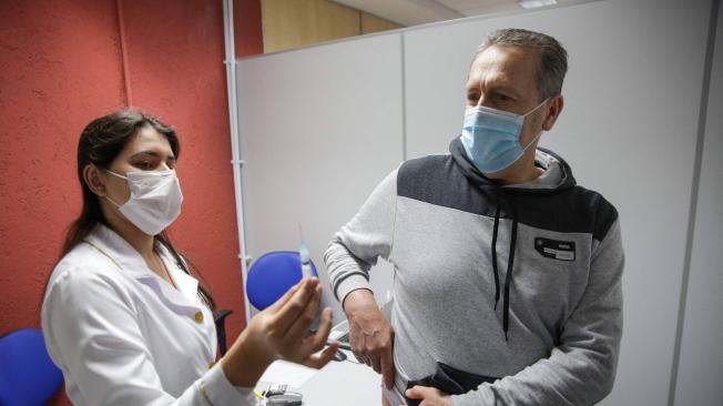 Un hombre se prepara para recibir un pinchazo de la vacuna Pfizer-BioNtech en el Centro de Eventos de Cau Hansen, ubicado en la ciudad de Joinville.