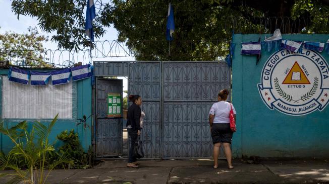 Dos mujeres hablan en la entrada del centro de votación Camilo Zapata en Managua (Nicaragua).