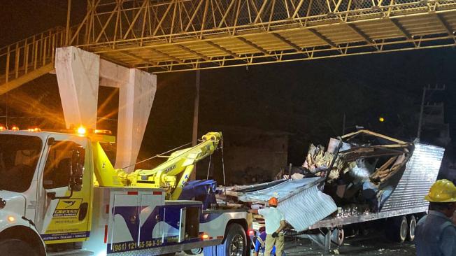 Trabajadores retiran el contenedor del remolque de un camión que se estrelló con migrantes a bordo durante un accidente de tránsito en Tuxtla Gutiérrez, estado de Chiapas, México, el 9 de diciembre de 2021.