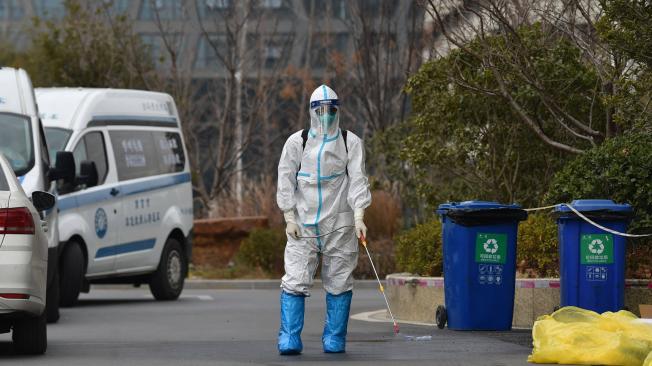 Un miembro del personal rocía desinfectante fuera de un hotel después de que una persona dio positivo por el coronavirus Covid-19, en Nanjing, en la provincia oriental de Jiangsu, el 28 de diciembre de 2021.