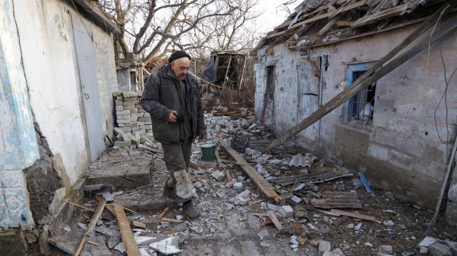 Un residente camina alrededor de una casa destruida como resultado del bombardeo en la aldea de Tamarchuk cerca de Marinka, Ucrania, controlada por militantes prorrusos.