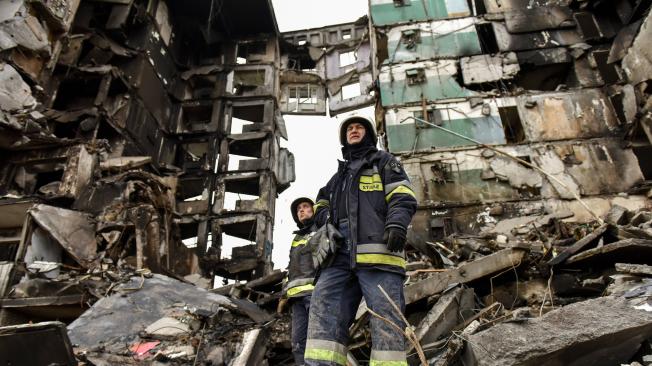 Los trabajadores de emergencia buscan entre los escombros de un bloque de apartamentos destruido en la ciudad de Borodyanka, cerca de Kiev, Ucrania.
