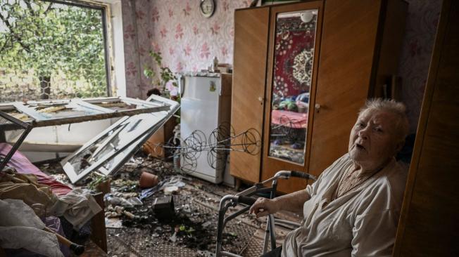 Una anciana se sienta dentro de su casa dañada después de un ataque con misiles en la ciudad de Soledar, en la región oriental de Ucrania de Donbas el 4 de junio de 2022.