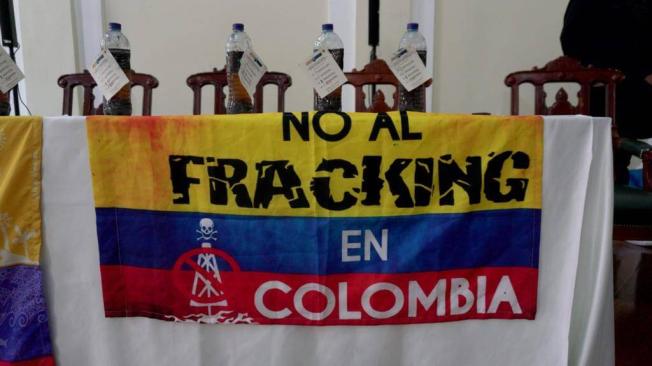 En la mesa donde estaban sentados la ministra de Ambiente, los congresistas y el director de la Alianza Anti Fracking, se leía un cartel con la bandera de Colombia que tenía escrito "No al fracking".