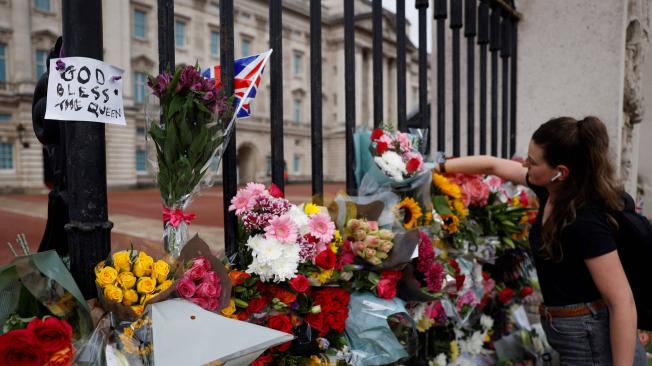 Cientos de personas han dejado arreglos florales en las puertas del palacio en honor a la reina.