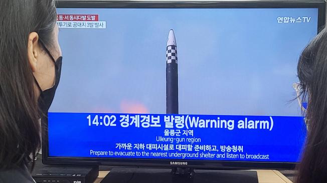 La gente ve las noticias sobre el levantamiento de una alarma antiaérea en una oficina en Seúl.
