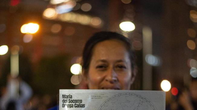 Familiar de María del Socorro Ortega Cañas, sostiene uno de los planisferios del cielo en la acción pública de este año.