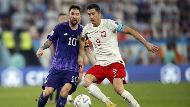 Robert Lewandowski (d) de Polonia disputa un balón con Lionel Messi de Argentina hoy, en un partido de la fase de grupos del Mundial de Fútbol Qatar 2022 entre Polonia y Argentina en el Estadio 974 en Doha (Catar).