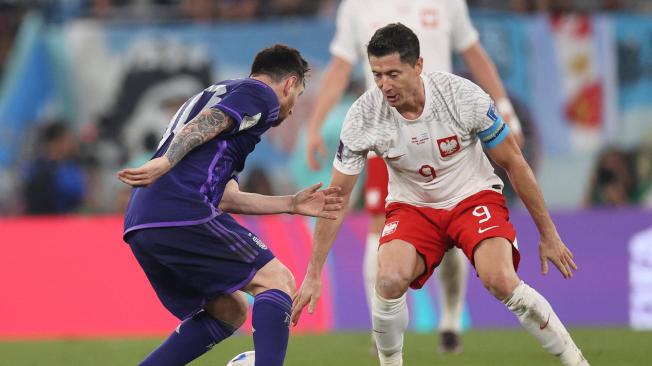 Robert Lewandowski (d) de Polonia disputa un balón con Lionel Messi de Argentina hoy, en un partido de la fase de grupos del Mundial de Fútbol Qatar 2022 entre Polonia y Argentina en el Estadio 974 en Doha (Catar).