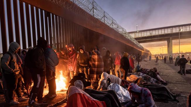 Migrantes en la frontera México-Estados Unidos intentan mantenerse calientes