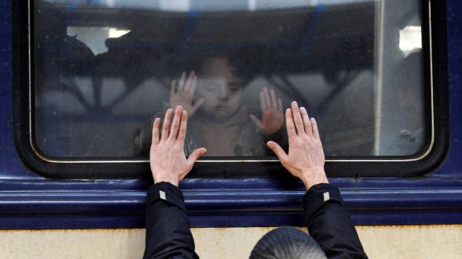 Un hombre despide a una niña que está en un tren en Ucrania.