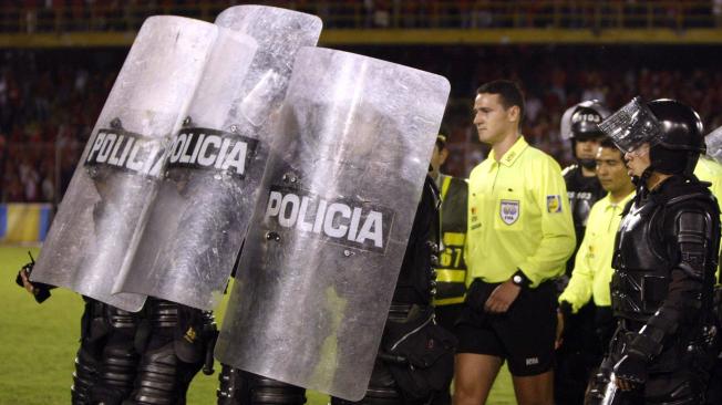 Wílmar Roldán sale protegido por la policía tras el primer partido de la final entre América y Chicó, en 2008.