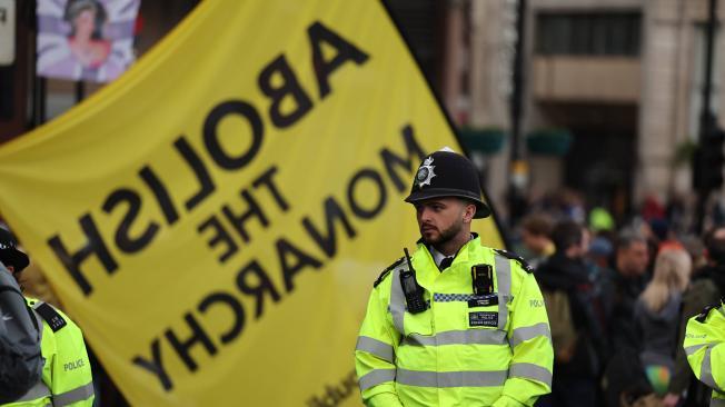 Un policía observa a miembros del grupo antimonárquico Republic protestando el día de la Coronación del Rey Carlos III de Gran Bretaña en Londres.