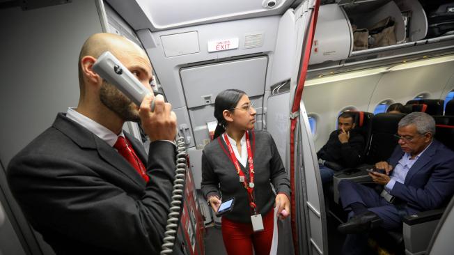 Antes de cerrar las puertas del avión y empezar a dar instrucciones a los pasajeros, el jefe de cabina recibe de una de las agentes de servicio el reporte oficial del número de pasajeros y las novedades del vuelo.